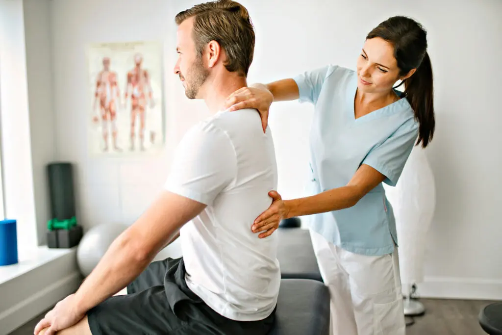 Physiotherapist treating patient's back pain.