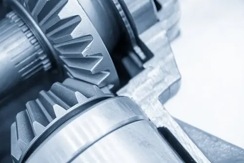 Close-up of interlocking metal gears in a machinery mechanism, showcasing precision engineering and mechanical details, including the intricate alignment of the ring and pinion.