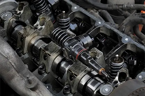 Detail of modern diesel engine repair, closeup of injectors in cylinder head with camshaft