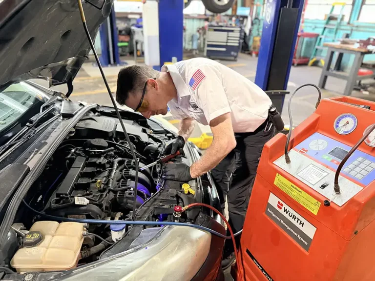 ASE-certified technician performing automotive air conditioning service at Harrell & Beverly Transmissions & Auto Repair in Sanford, Florida.