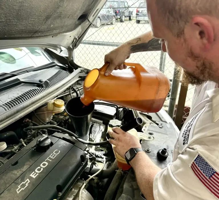 ASE-certified technician performing a fluid service as part of vehicle maintenance at Harrell & Beverly Transmissions & Auto Repair in Sanford, Florida.