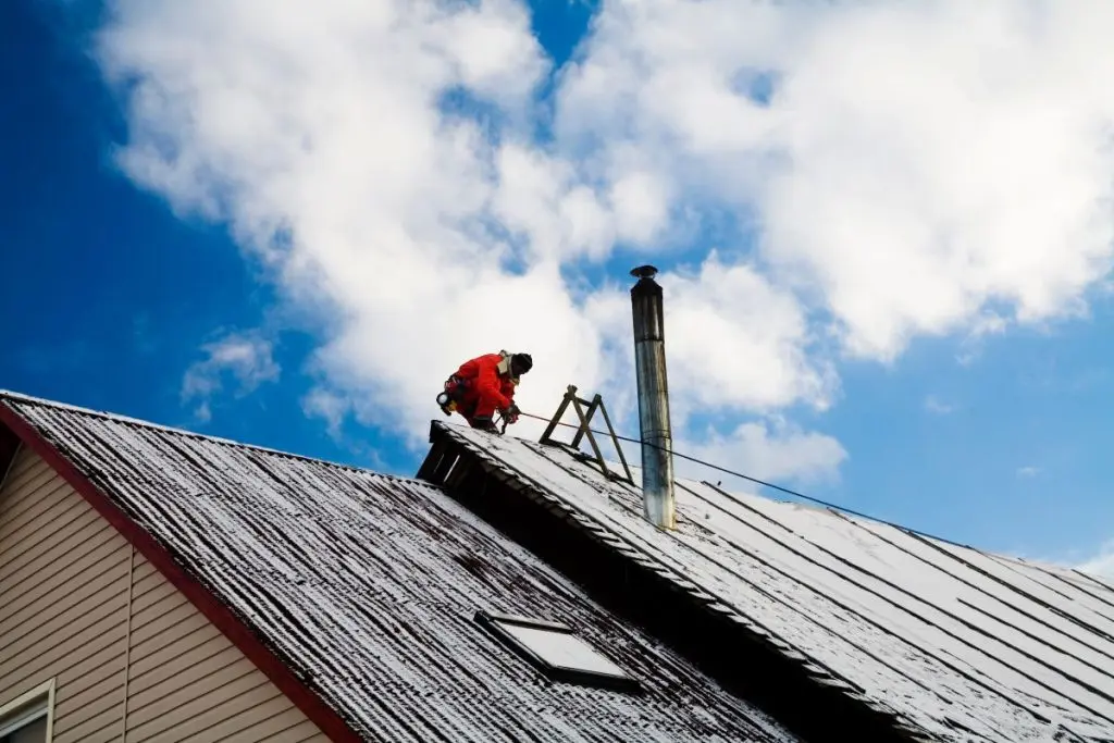 repairman on a roof during winter