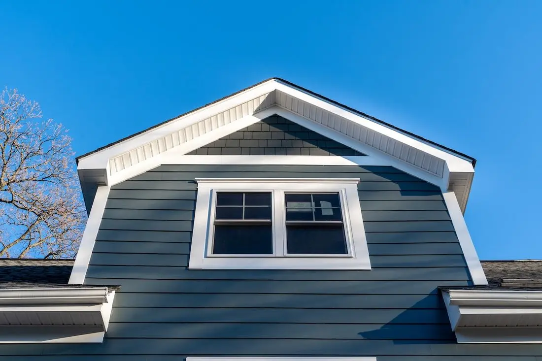 New restoration facade with double hung window w/ fixed top sash and bottom sash that slides up, divided by two white grilles, thick elegant frame, blue vinyl siding