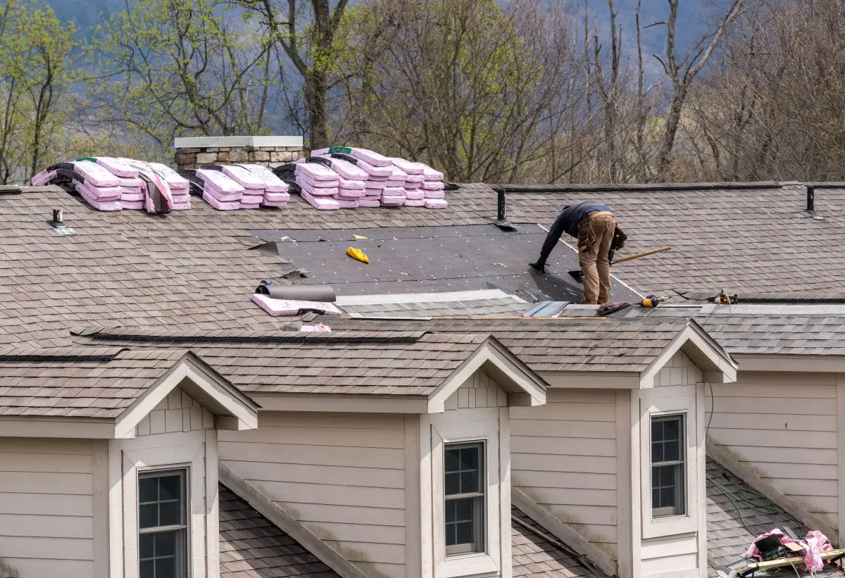 Roofing contractor removing the old tiles before replacing with new shingles on a townhouse roof, Shoreview