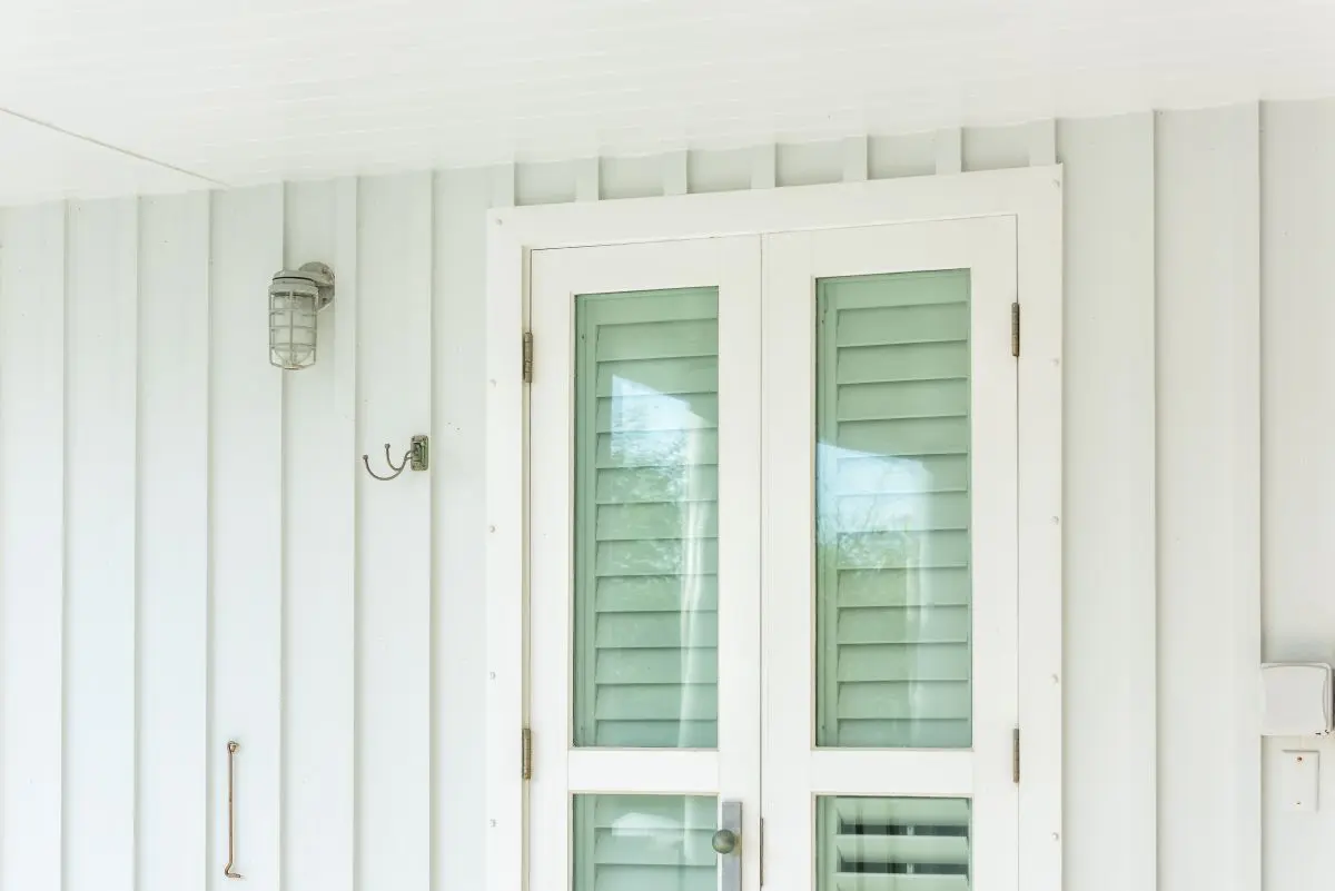Pastel green colorful hurricane window shutters architecture open exterior of house