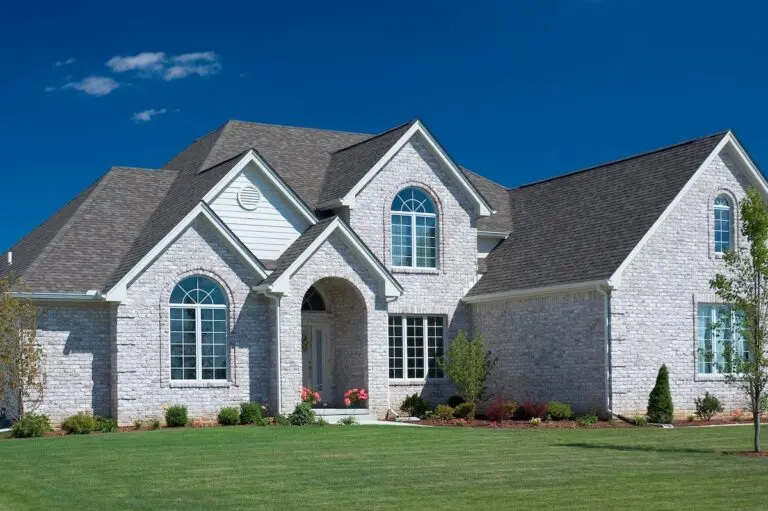 Roofing Fridley Beautiful white brick home featuring some fantastic brick details, Nice blue sky background to set the photo off nicely.