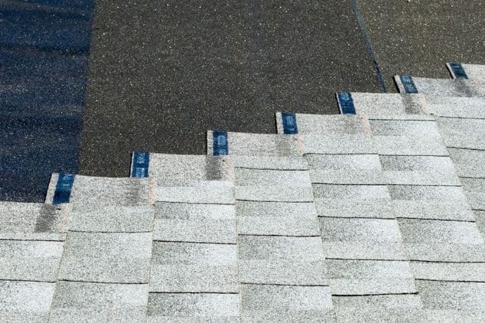 asphalt shingles being installed on top of roof underlayment