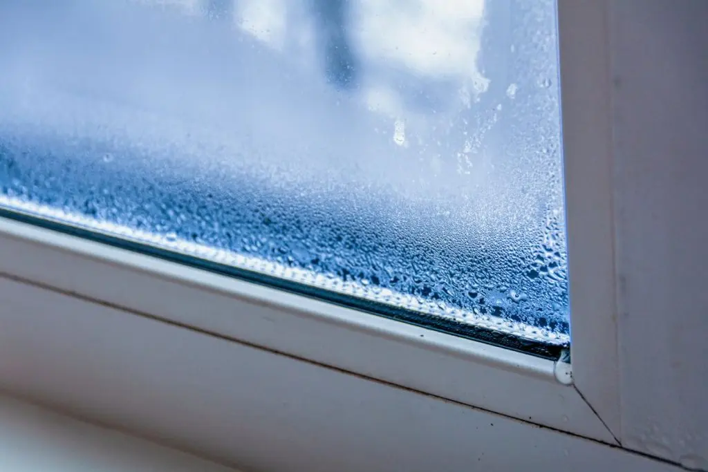 A fragment of a plastic window with condensation of water on the glass