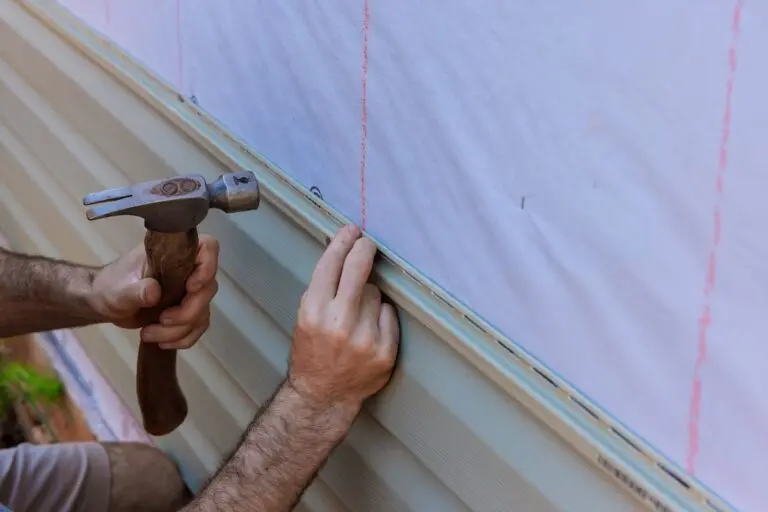 Handyman installs vinyl PVC siding on new home facade