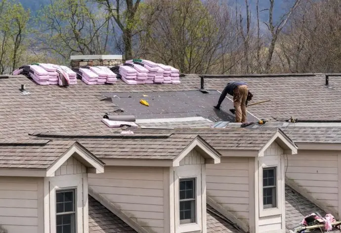 Roofing contractor removing the old tiles before replacing with new shingles on a townhouse roof, Shoreview