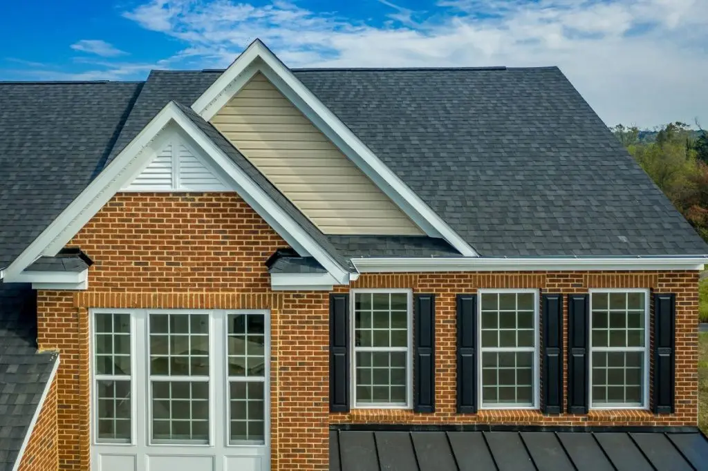 Beautiful luxury American colonial traditional estate model home on a new development with two car garage, brick siding, fiber cement shingle gable roof