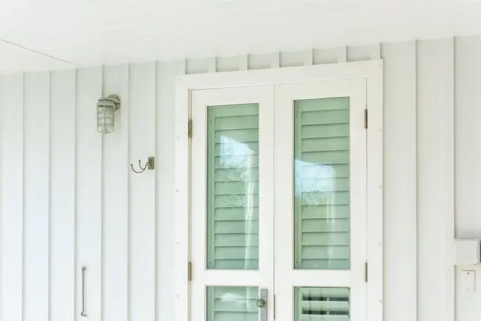 Pastel green colorful hurricane window shutters architecture open exterior of house