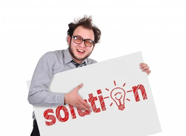 A guy holding a sign that says "Solution"