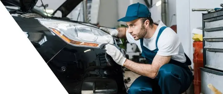 img - handsome-car-mechanic-looking-tail-light-black-car