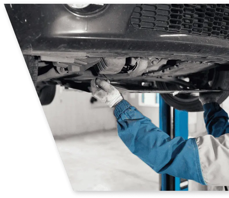 Sheridan car mechanic doing oil change on a car in a lift