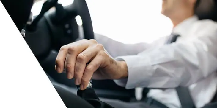man in a business attire driving a car