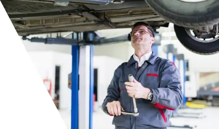 car mechanic examining car transmission for repair