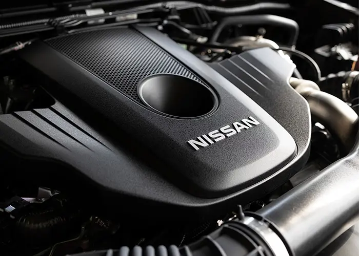 A close-up view of a Nissan car engine, revealing its intricate mechanical components and design.