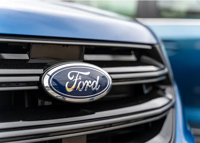 A close-up view of a blue Ford car's grille