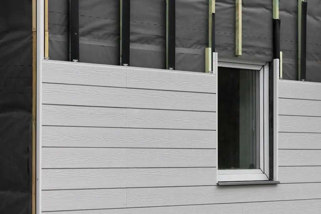wood texture composite cladding installation on house facade. WPC exterior wall panels