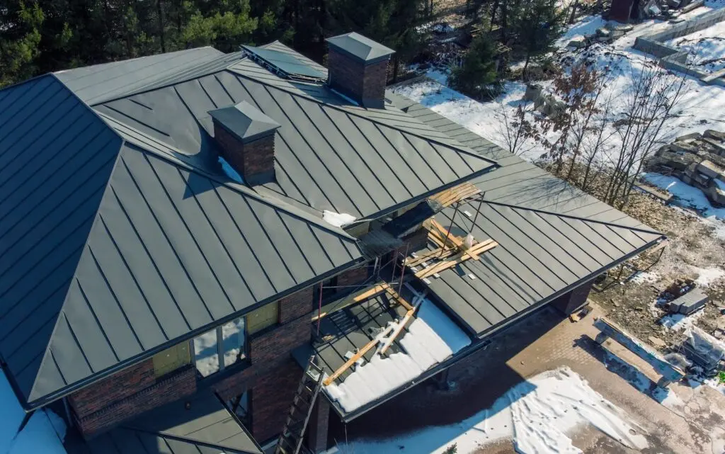 Aerial top view of new modern residential house cottage water heat system on roof. Renewable ecological green energy production concept. Winter time.