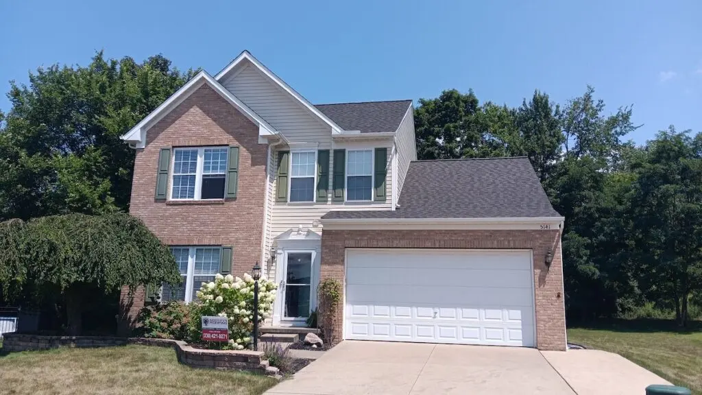 Family house with attached garage, brick and gray roof
