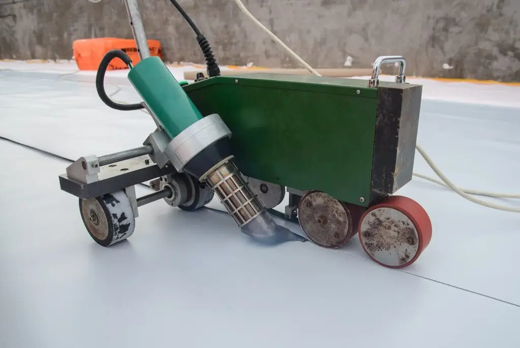 Waterproofing and insulation at construction site, roof sealing process of synthetic membrane with Automatic plastic welder. New protection technology