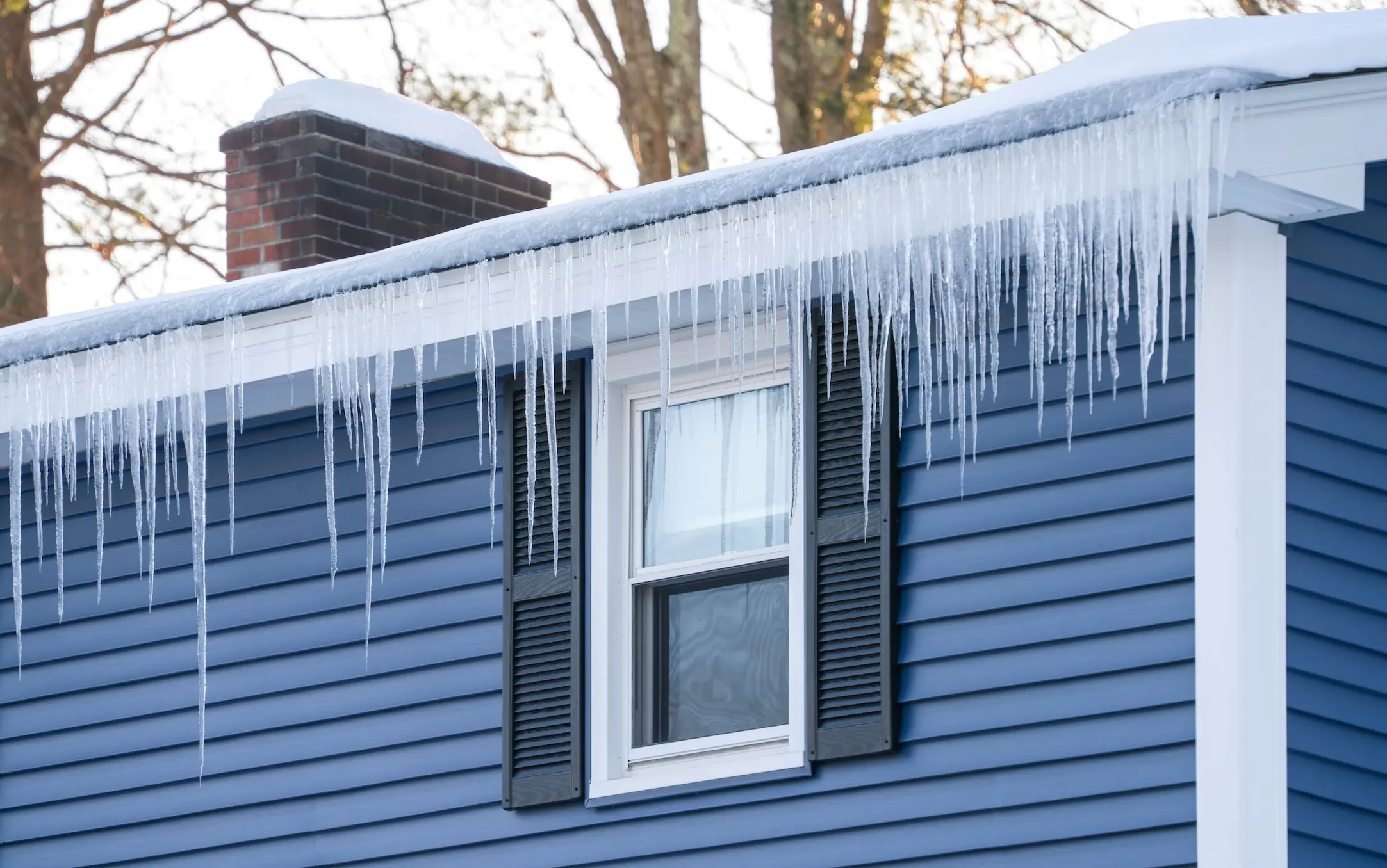 winter house with icicle and snow on the roof