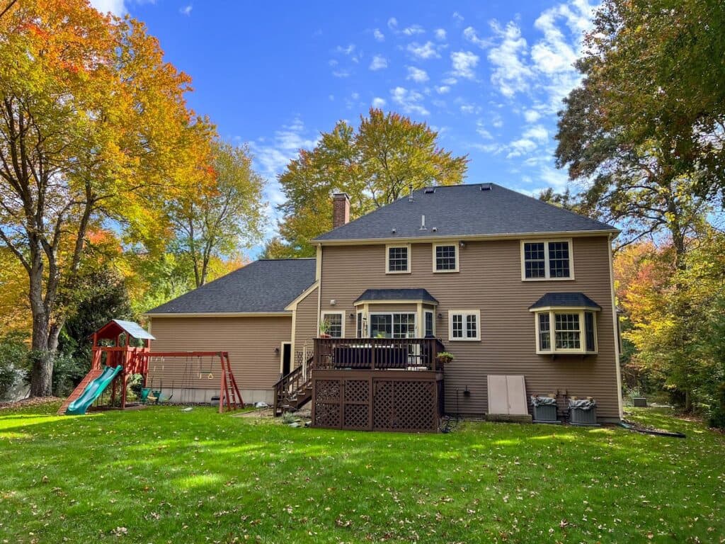 roof types back of hip roof colonial house with swingset, deck, and bulkhead
