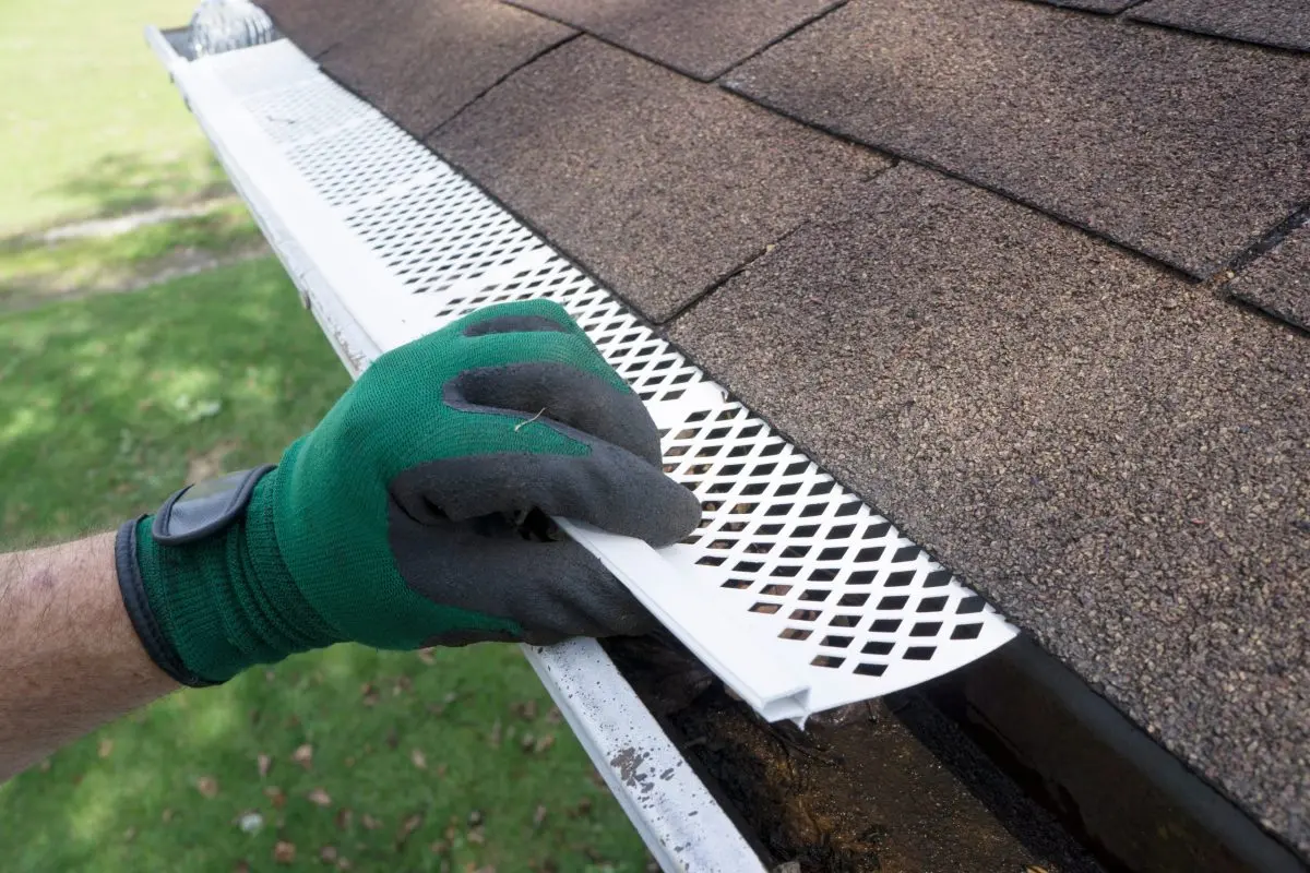 gutters garner nc Contractor adjusting plastic gutter guards to get them to fit.