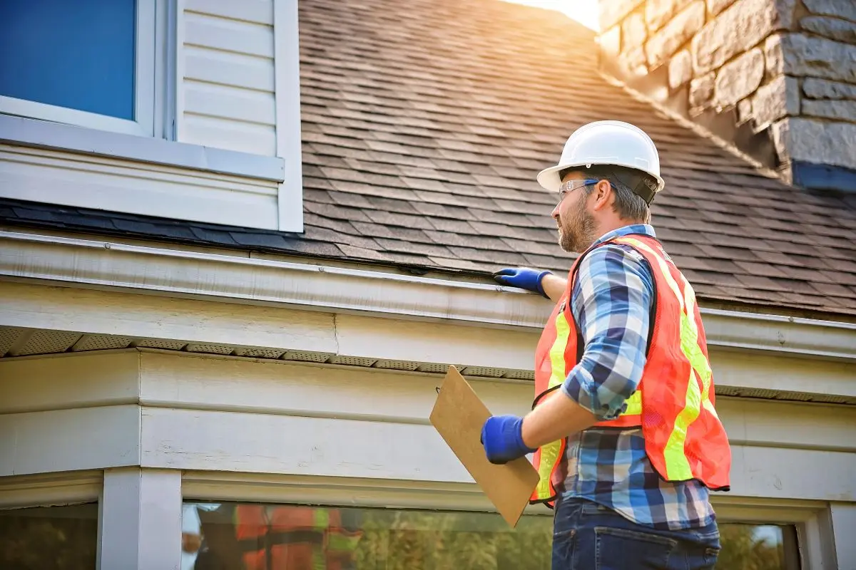 guy using helmet doing roof inspection