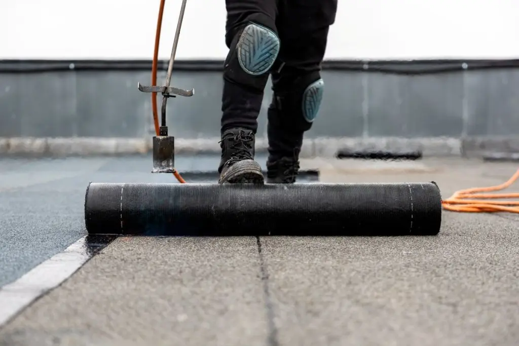 worker using torch on top of roof