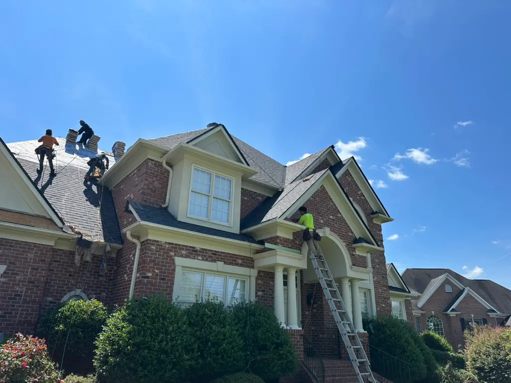 best roofing companies in wake forest nc workers on top of big house roof