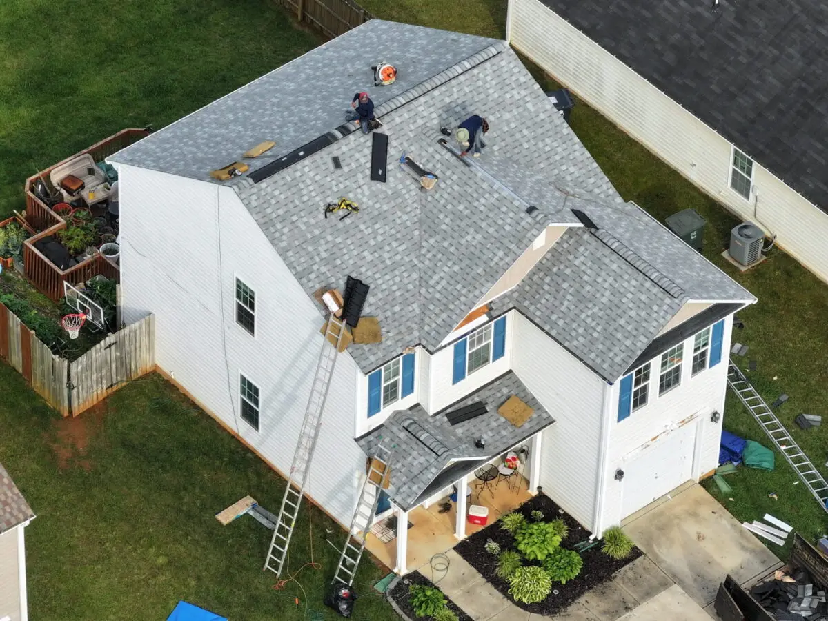 roofing companies garner nc roofers repairing grey roof white big house drone shoot