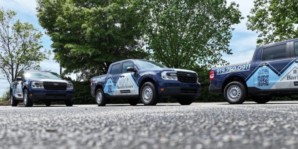 roofing companies garner nc branded Barkley-Jensen Roofing trucks on the street
