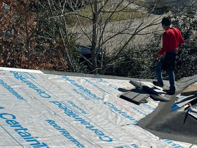woman on top of shingles roof