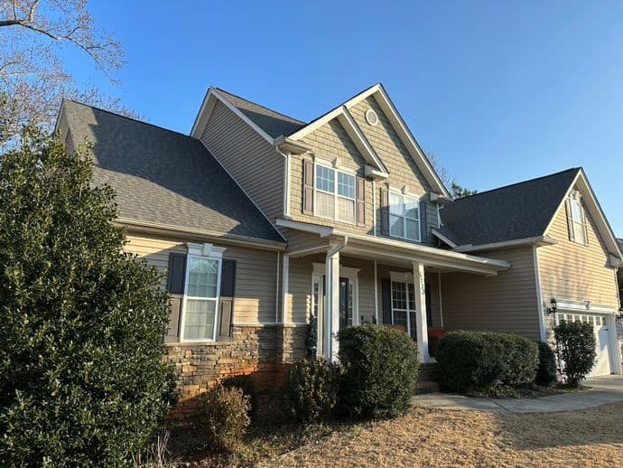 best roofing companies in fuquay varina nc worker installing new roof new big house blue sky