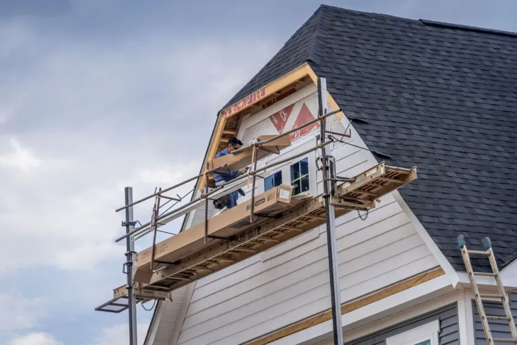 worker installing siding companies raleigh nc close to grey roof