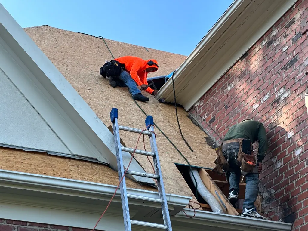 best roofing companies in cary nc worker on top of roof removing shingles