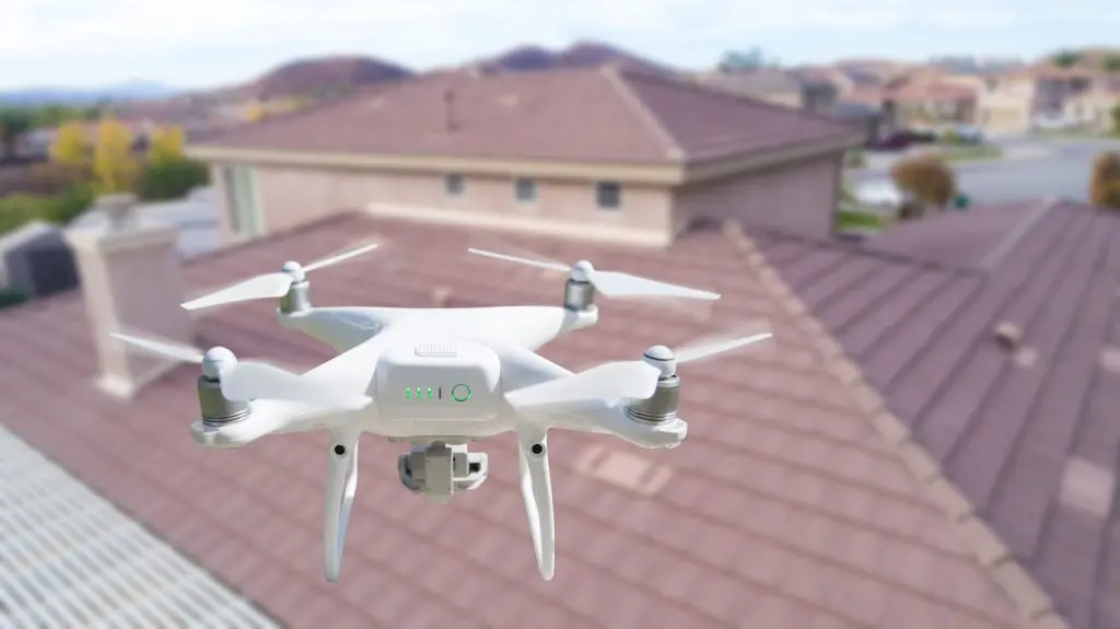 what is included in a full roof replacement in holly springs nc Unmanned Aircraft System (UAV) Quadcopter Drone In The Air Over House Inspecting the Roof.