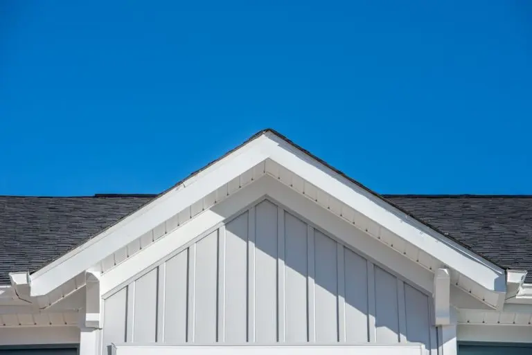Gable roof with white fascia, gray vertical vinyl lap siding. Vinyl Siding Cost