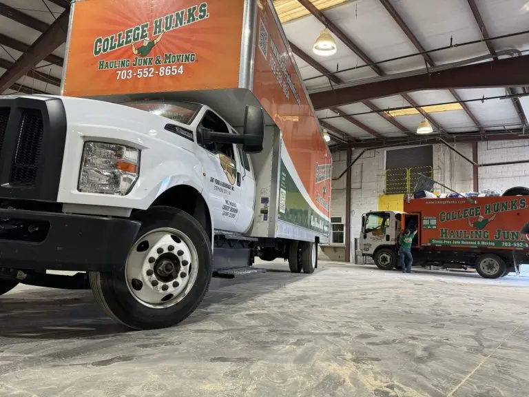 College HUNKS junk and moving trucks in a franchise warehouse, the operation behind a junk removal franchise investment