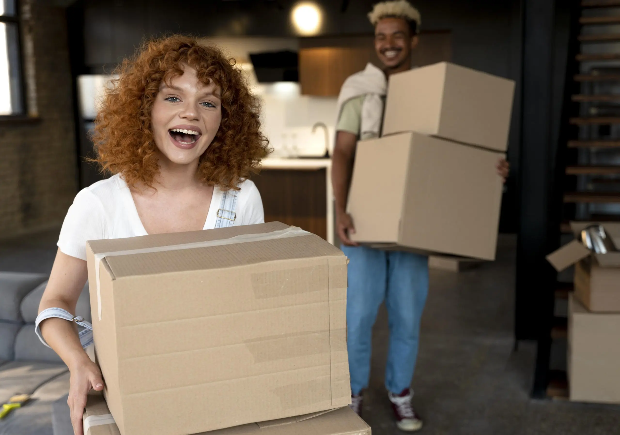 Couple carrying moving boxes through an apartment, the needs-based move a recession resistant franchise is built around