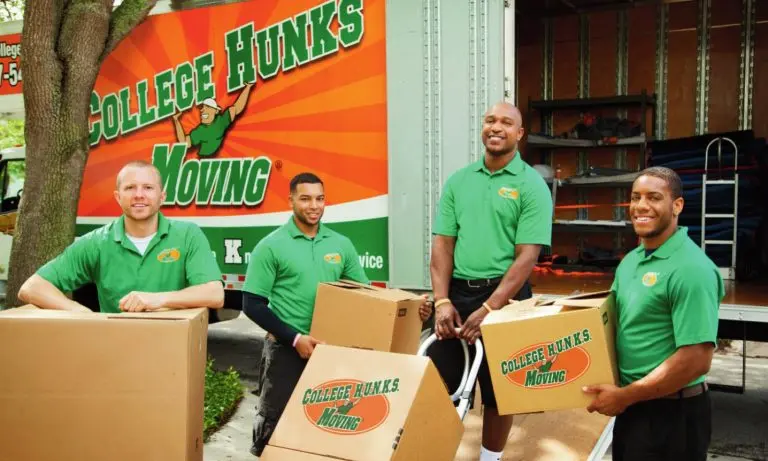 College HUNKS moving crew holding branded boxes at the back of an open moving truck