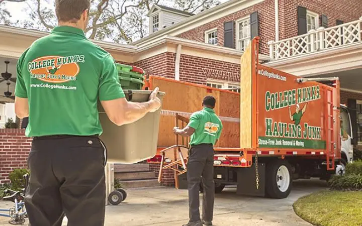 College HUNKS crew loading a branded junk removal truck