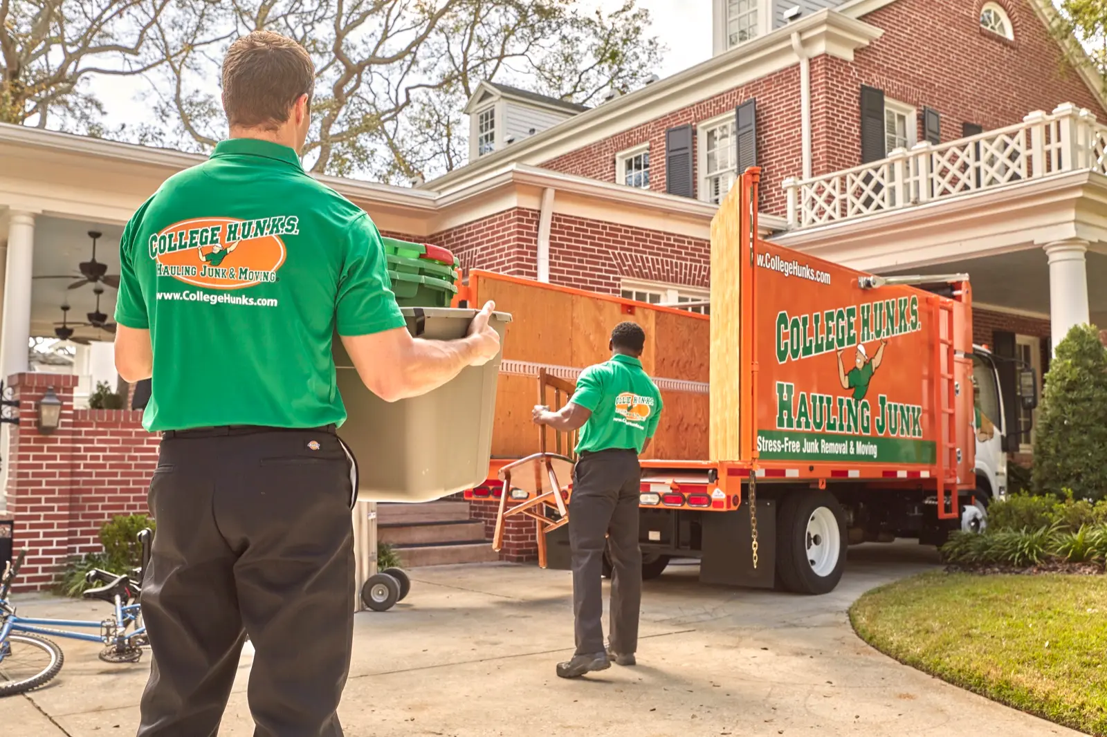 College HUNKS crew loading the junk removal truck, the second revenue line in a two-in-one moving franchise