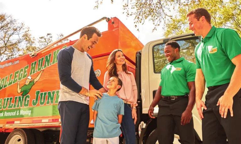 College HUNKS crew talking with a family beside the truck, the local business a veteran owner can finance and run