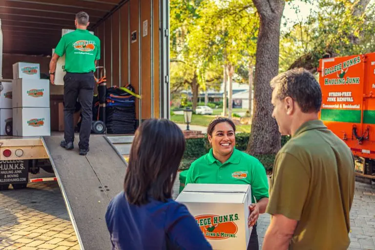 College HUNKS movers loading boxes up a truck ramp while talking with customers
