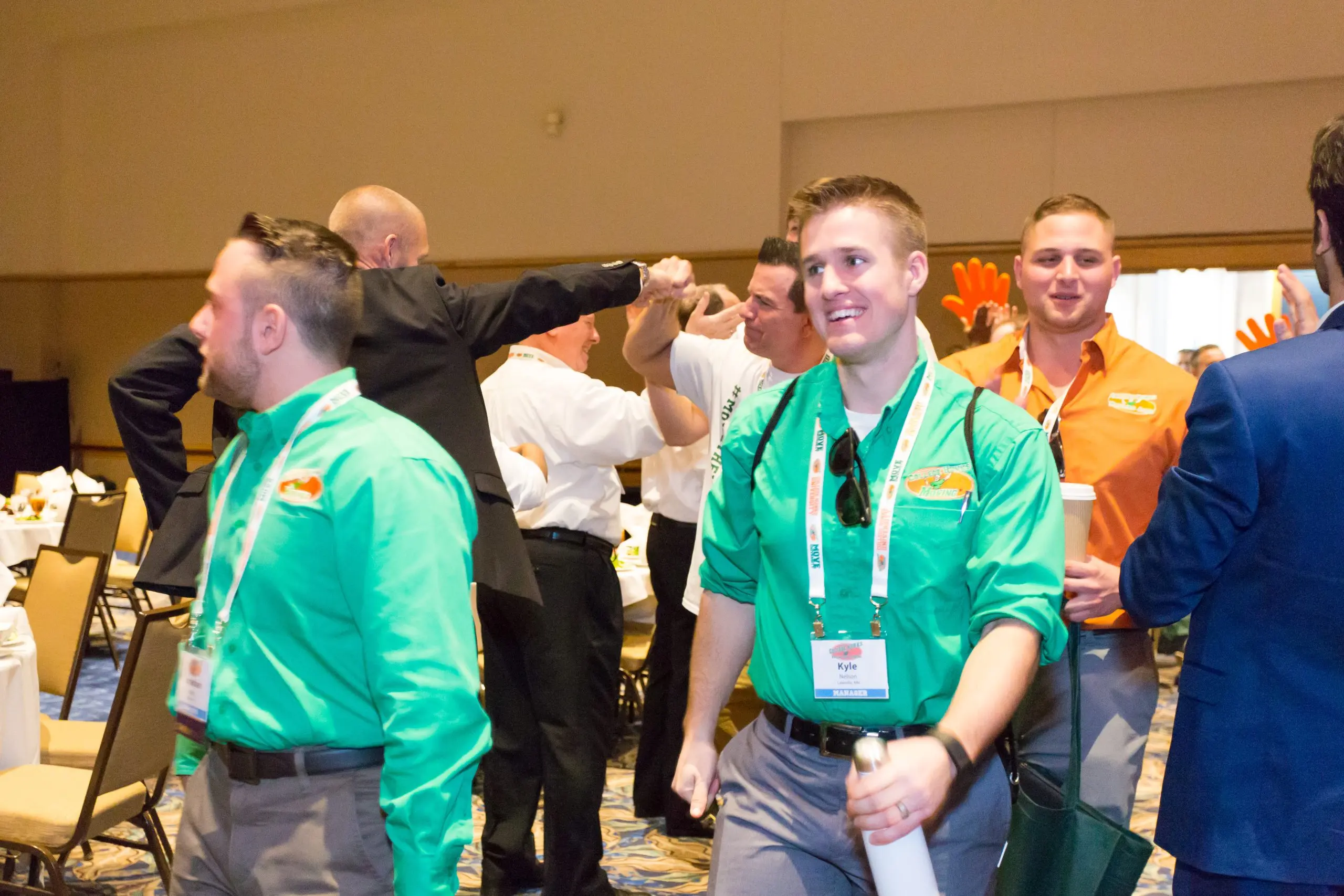 College HUNKS franchise owners high-fiving at a system conference, the peer network an owner gets in place of an MBA cohort