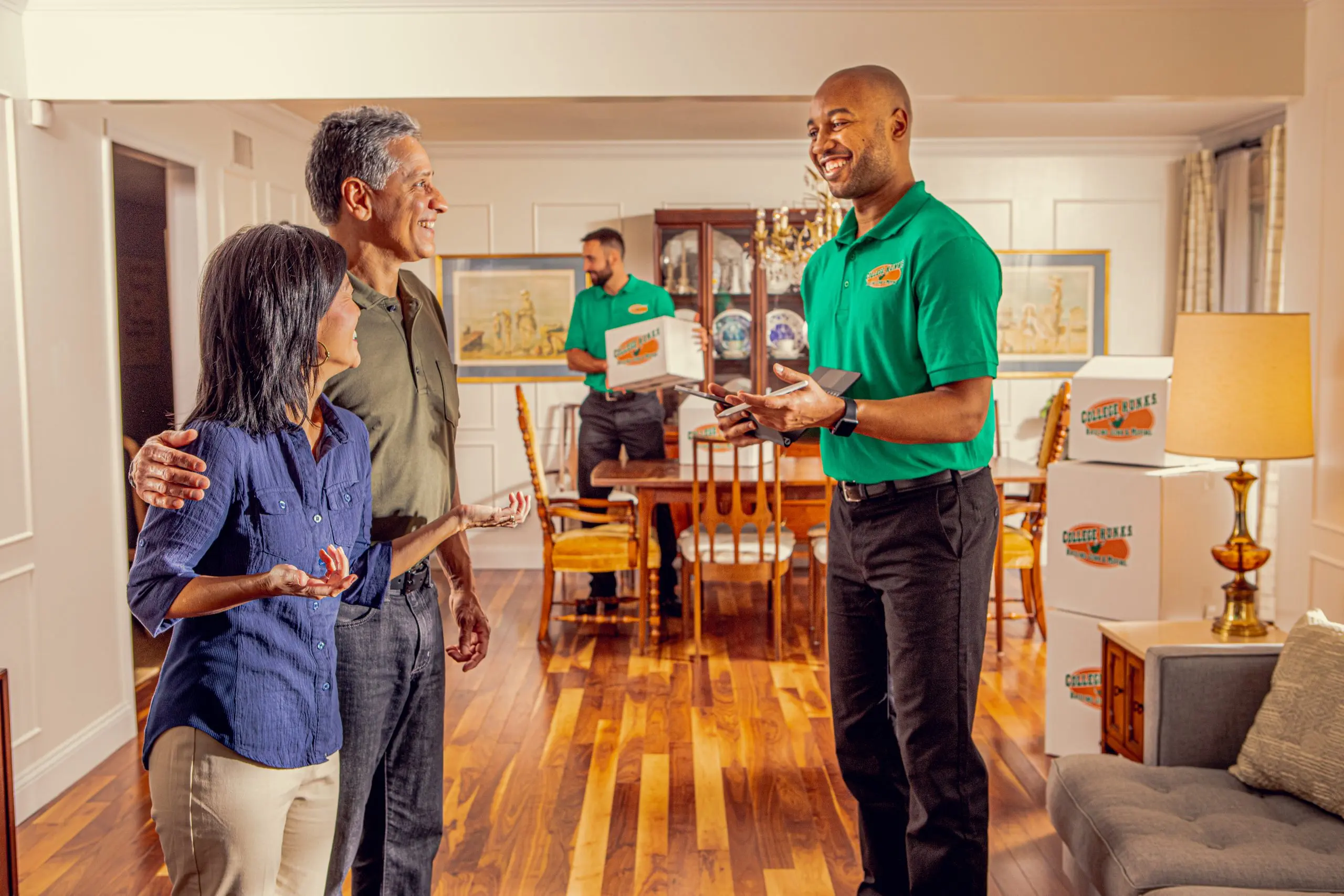 College HUNKS team member talking with a homeowner couple in their dining room